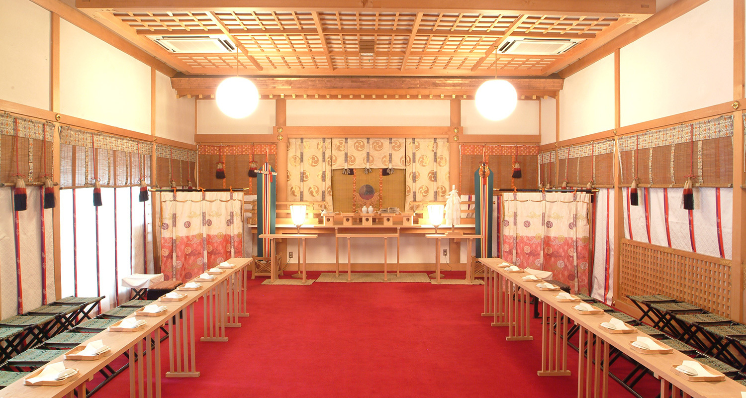 赤絨毯と白木の祭壇が整えられた二荒山神社祭殿の内部と参列者席