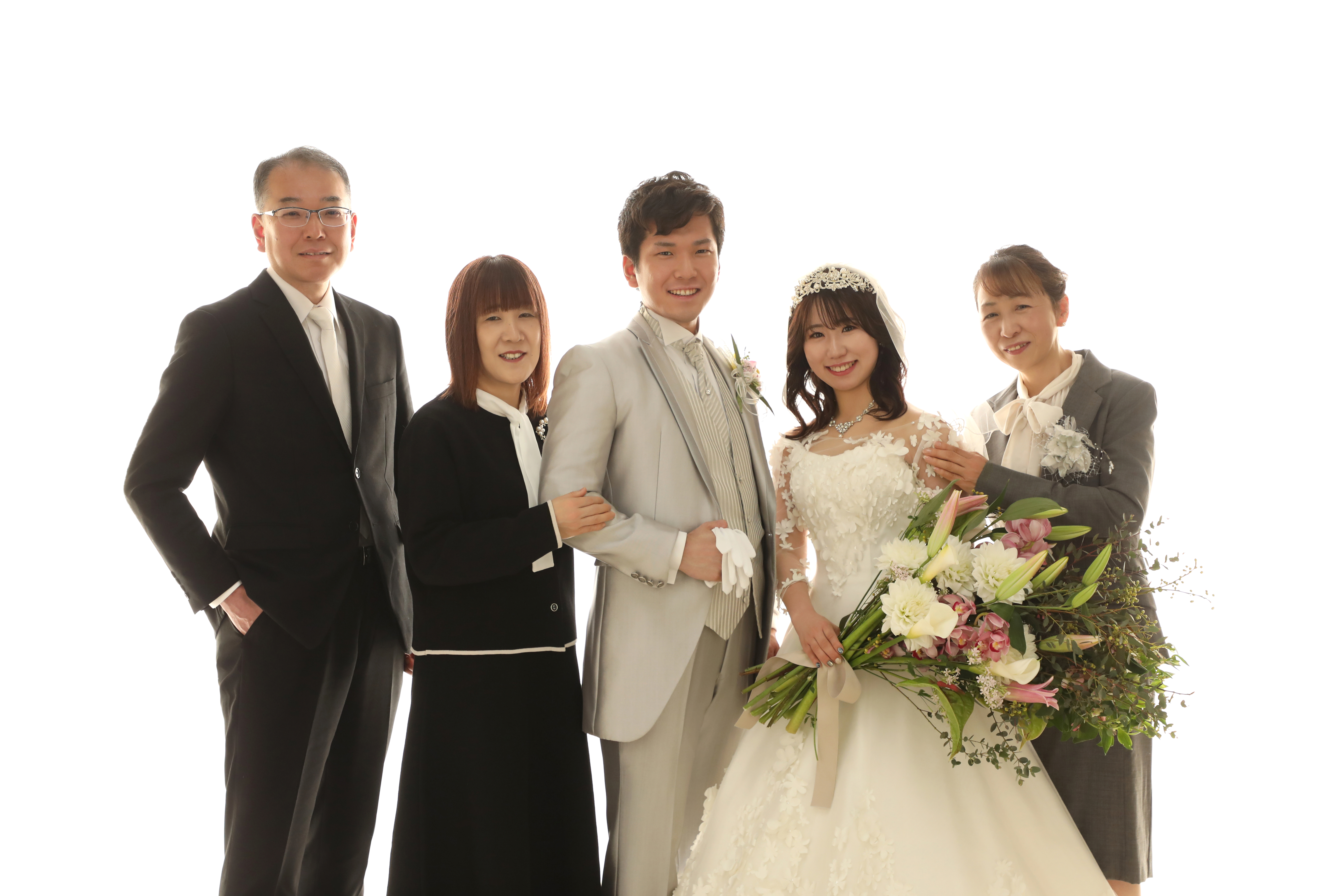 白ホリゾントで両家のご両親と並ぶウェディングドレスの新婦と新郎