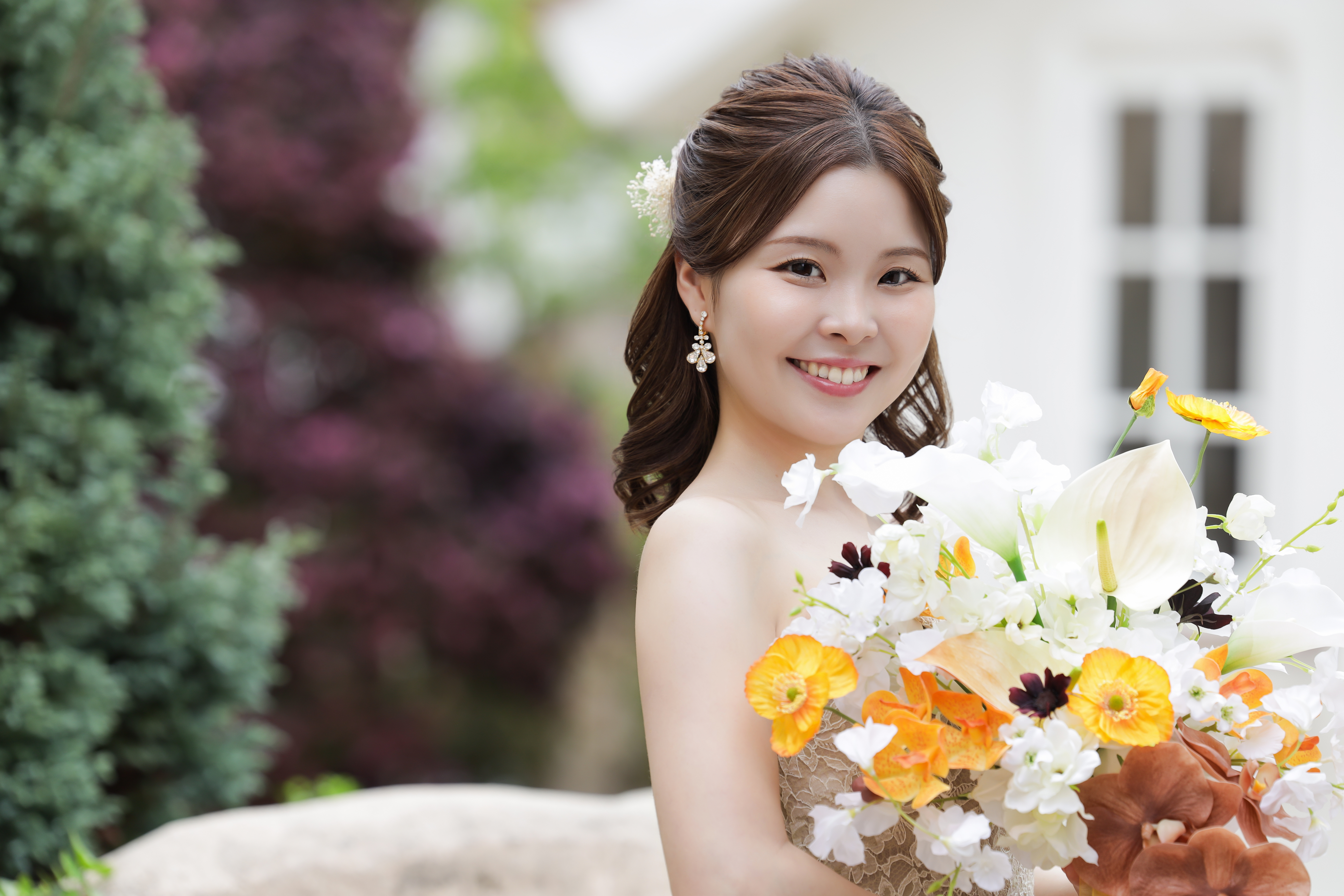 ビタミンカラーのブーケを抱えて振り返り微笑むドレス姿の新婦